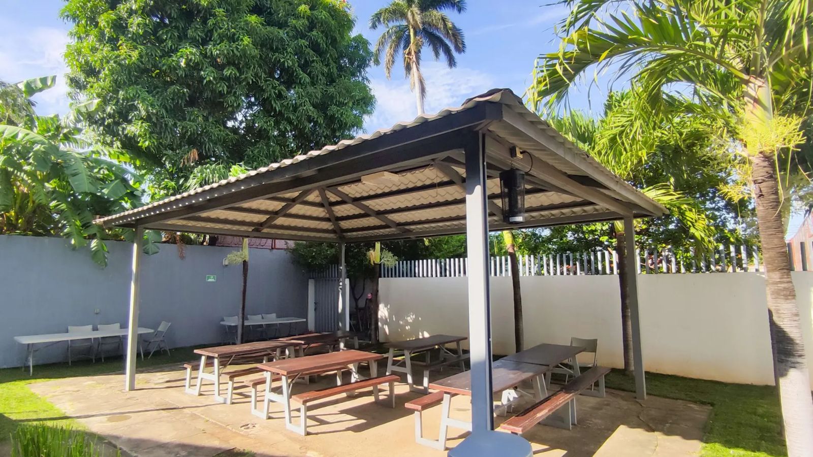 Ranchito con mesas de madera rodeado de palmeras